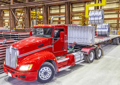 Red heavy-duty truck with flatbed for construction materials